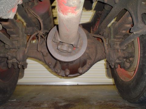 1966 International School Bus - Close-up view of the rear axle and driveshaft of a heavy-duty vehicle, showing mechanical components.