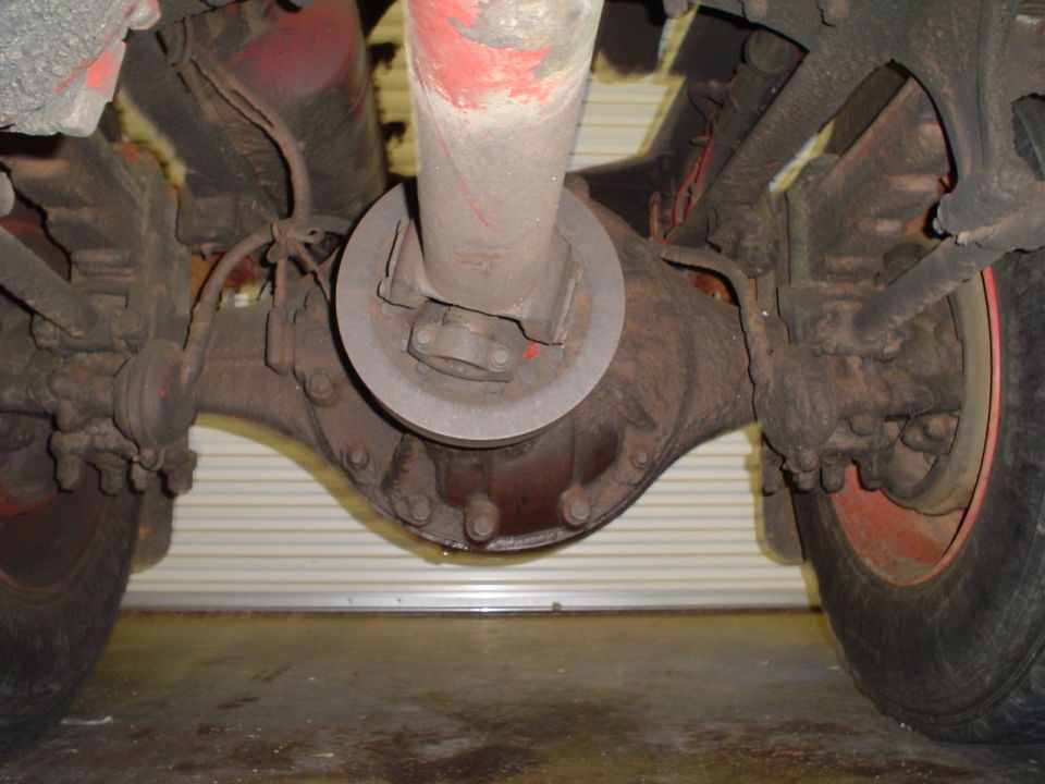 Underside of heavy truck drive axle showing differential carrier and driveshaft