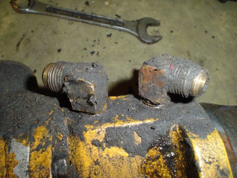 1966 International School Bus - Close-up of a greasy engine component with fittings, suggesting a diesel engine part.