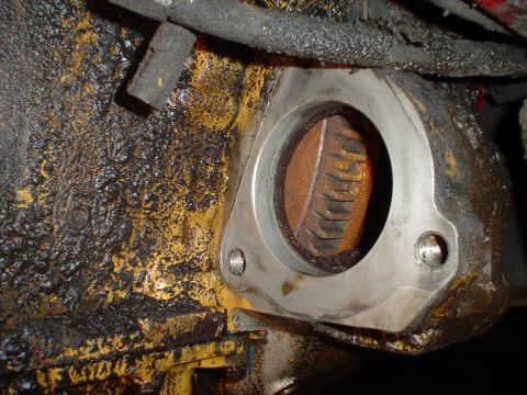1966 International School Bus - A close-up view of a greasy engine component, showing a metal flange and internal gears.