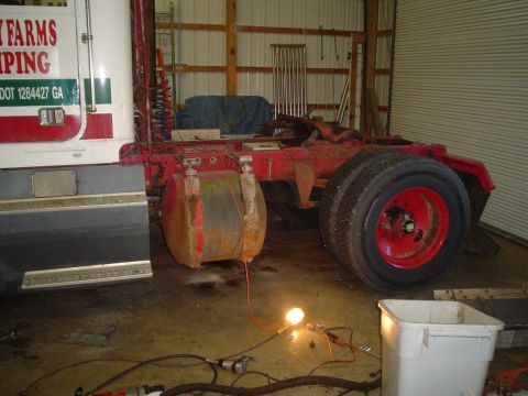 1966 International School Bus - This is a side view of a semi-truck chassis, a fuel tank and a large rear tire. Text on the cab reads 'Farms Camping'.