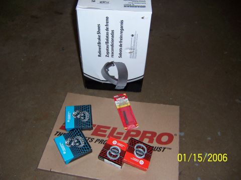 1987 Ford Bronco - A box of brake shoes and several boxes of bearings are laid out on a piece of cardboard.