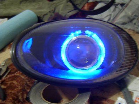 1998 Ford Taurus - This is a close-up of a vehicle headlight with a blue halo light, likely a custom modification.