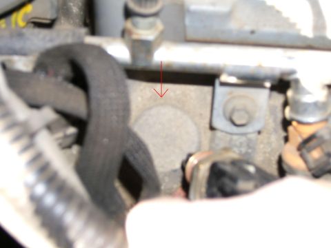 1990 Ford Bronco - A close-up view of engine parts, with a red arrow indicating a specific component.