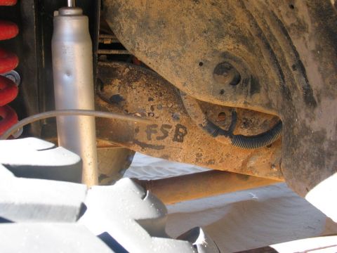 1995 Ford Bronco - The frame of a vehicle shows the marking 'FSB' in black paint, indicating it's part of the suspension system.