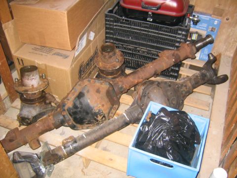 1978 Ford Bronco - Vehicle axles and a hub assembly are stored on wooden pallets.