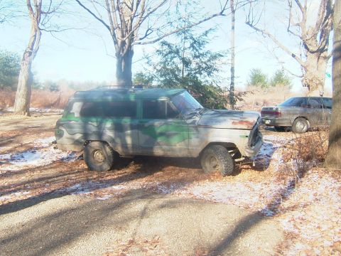1984 Ford Bronco - This camouflaged SUV appears to be in a state of disrepair, with visible rust on its front end.