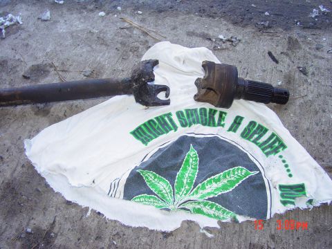 1995 Dodge 1500 - A driveshaft part rests on a t-shirt with a marijuana leaf graphic and text.