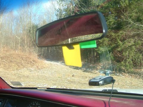 1984 Ford Bronco - View through the windshield includes a radar detector and notes hanging from the rearview mirror.
