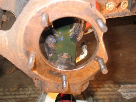 1995 Ford Bronco - Rusted wheel hub assembly showing internal components and green fluid.