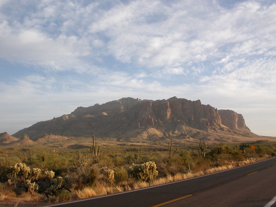Desert mountains and saguaro cacti next to a road
