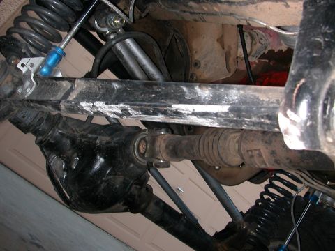 1984 Ford Bronco - Close-up of the suspension and drivetrain components of a vehicle's undercarriage.