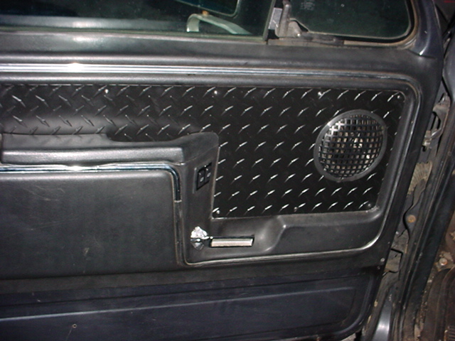 Black door panel with diamond-plate insert and round speaker grille