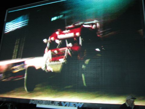 1990 Ford Bronco - jumbotron displays a red off-road race truck mid-jump, with 'MOBILE VIEW' lettering across the bottom of the screen.
