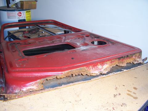 1978 Ford Bronco - A heavily rusted red vehicle door is shown, indicating significant deterioration.