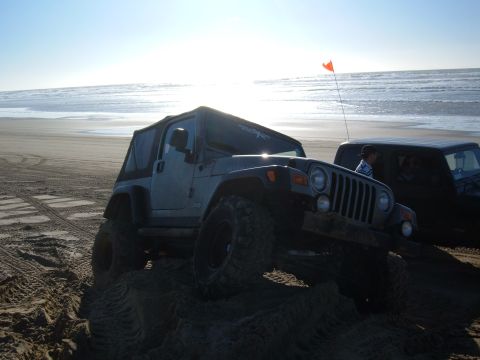 1985 Ford Ranger - Two off-road vehicles on a sandy beach with the ocean in the background.