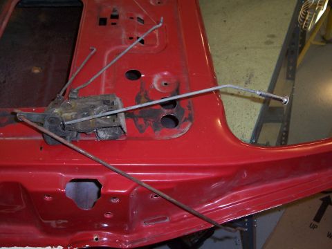 1978 Ford Bronco - Close-up of a car door's internal latch mechanism and connecting rods.