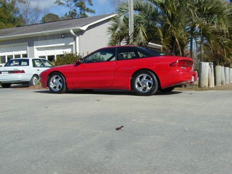 1997 Ford Probe - A red 1997 Ford Probe is parked outside a building with a white car nearby.