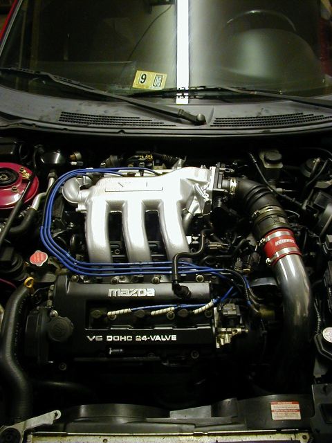 1997 Ford Probe - Engine bay view of a Mazda V6 DOHC 24-valve engine, a silver intake manifold and blue spark plug wires.