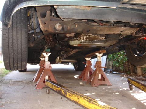 1993 Ford Taurus - The undercarriage of a vehicle is elevated on jack stands for maintenance.