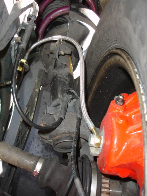 1993 Ford Taurus - Close-up of a car's suspension and brake system, showing a strut, spring, and caliper.