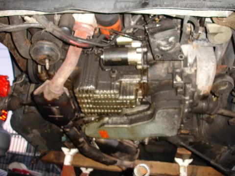 1993 Ford Taurus - Underside view of a car's engine and transmission components, including exhaust and starter.
