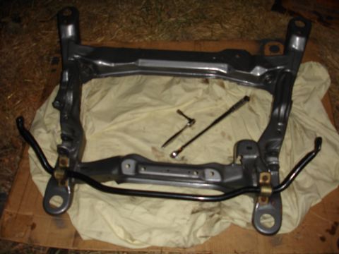 1993 Ford Taurus - A disassembled front subframe assembly, including a sway bar and tools, rests on a cloth.