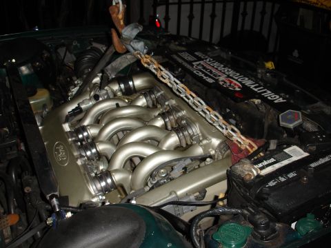 1993 Ford Taurus - Engine bay of a Ford vehicle, showing the V8 engine and associated components, with a chain hoist attached.