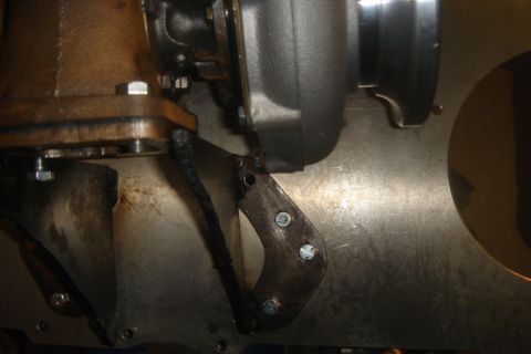 1969 Ford Mustang - Close-up of a turbocharger and its custom mounting bracket, showing bolted connections.