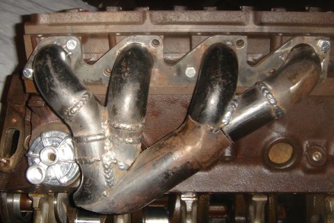 1969 Ford Mustang - Custom exhaust manifold fabricated and welded onto an engine block, likely for a performance build.