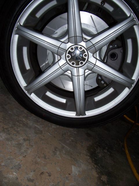 1998 Mercury Sable - This image shows a close-up view of a car's wheel, brake rotor, and caliper assembly.