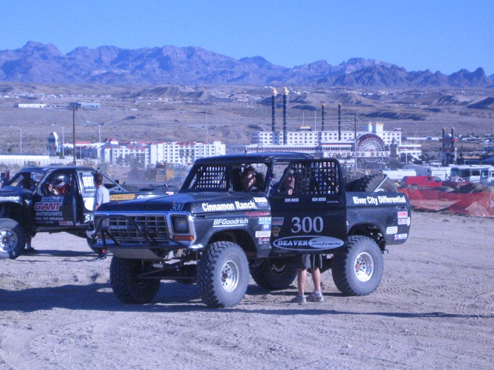 Black Ford race truck 300 parked in desert with casino buildings behind