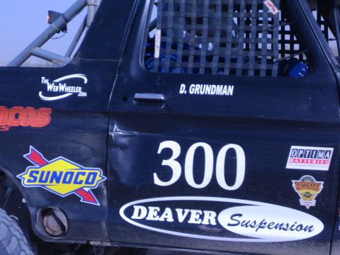 1990 Ford Bronco - driver door of a black race truck reads 300, "D. Grundman" and carries Sunoco and Deaver Suspension decals.