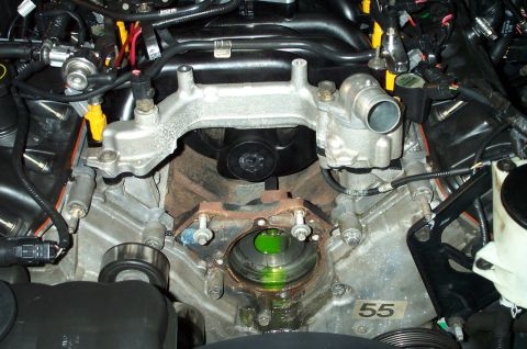 1998 Ford Crown Victoria - Close-up of an engine's intake manifold and water pump area, with green coolant visible.