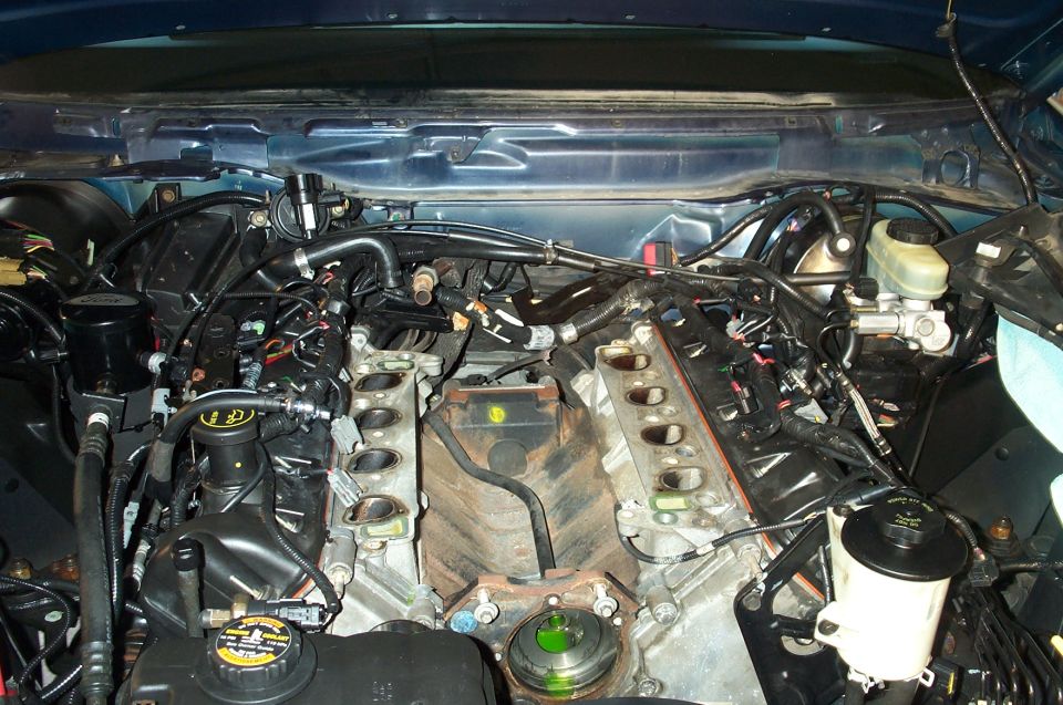 V8 engine bay with intake manifold removed, exposing cylinder head ports