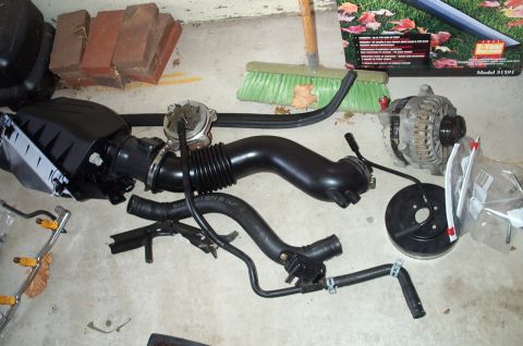 1998 Ford Crown Victoria - Various automotive components are visible on the floor, including an alternator and air intake system.