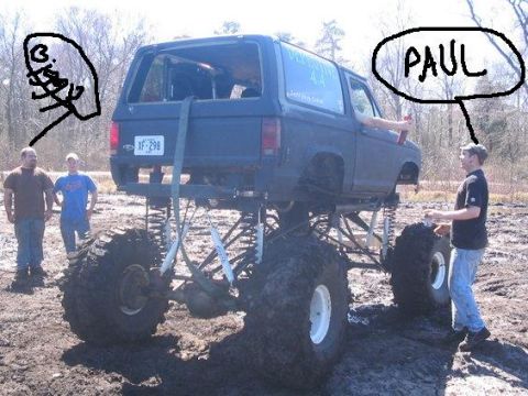 1987 Suzuki Samurai - This heavily modified SUV, with its massive tires and lifted suspension, appears to be stuck in the mud.
