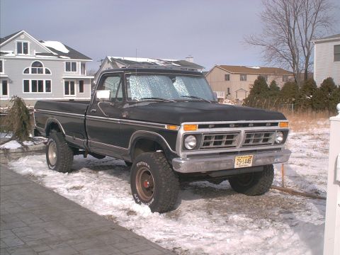 1978 Ford Bronco - This black Ford F-Series pickup truck, likely a 1977 model, is parked in a snowy driveway.