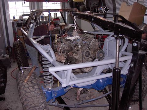 1981 Ford F-150 - Mechanic working on installing the engine into a custom off-road vehicle chassis.