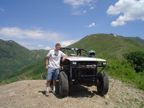 1981 Ford F-150 - A man poses next to a custom off-road buggy in a mountainous landscape.
