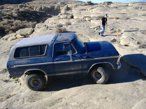1978 Ford Bronco - A blue 1978 Ford Bronco navigates a rocky, off-road landscape.