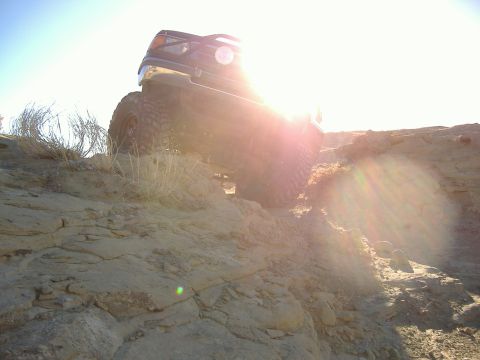 1978 Ford Bronco - A 1992 Ford Bronco navigates a steep, rocky incline under a bright sun.