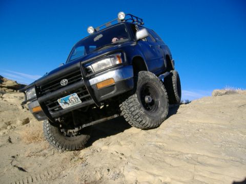 1978 Ford Bronco - This SUV is navigating a steep, rocky incline under a clear blue sky.
