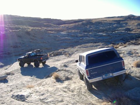 1978 Ford Bronco - A blue 1978 Ford Bronco navigates a rocky trail alongside a black pickup truck.