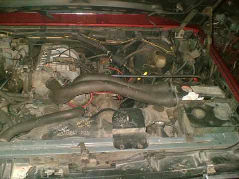 1989 Ford Bronco - Engine bay view showing the V8 engine and associated components. Text on fan shroud is visible.
