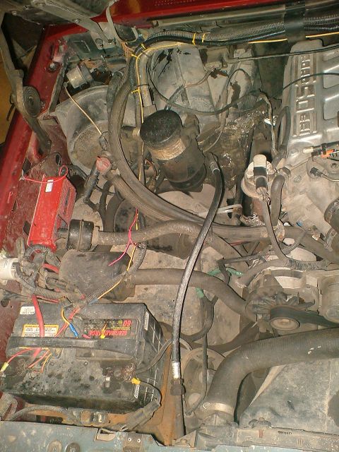 1989 Ford Bronco - Close-up view of a vehicle's engine compartment, showing various mechanical parts and wiring.