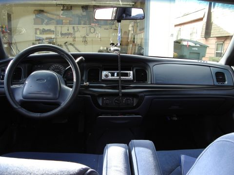 2000 Ford Crown Victoria - The interior of a 2000 Ford Crown Victoria is visible, including the dashboard and seats.