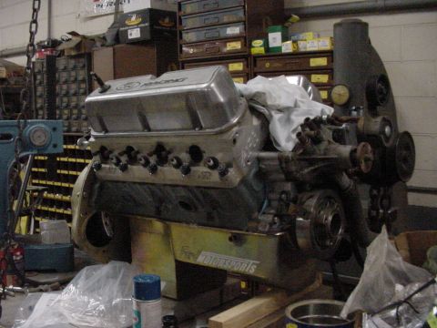 1978 Ford F-250 - Engine block with Ford Motorsports branding sits on a wooden stand in a workshop environment.