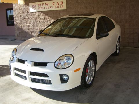 1996 Ford Probe - White Dodge Neon SRT-4 with red brake calipers is parked in a new car delivery area.