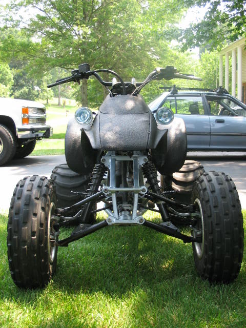 1987 Honda 250 X - A four-wheeler is parked on a lawn, with other vehicles visible in the background.